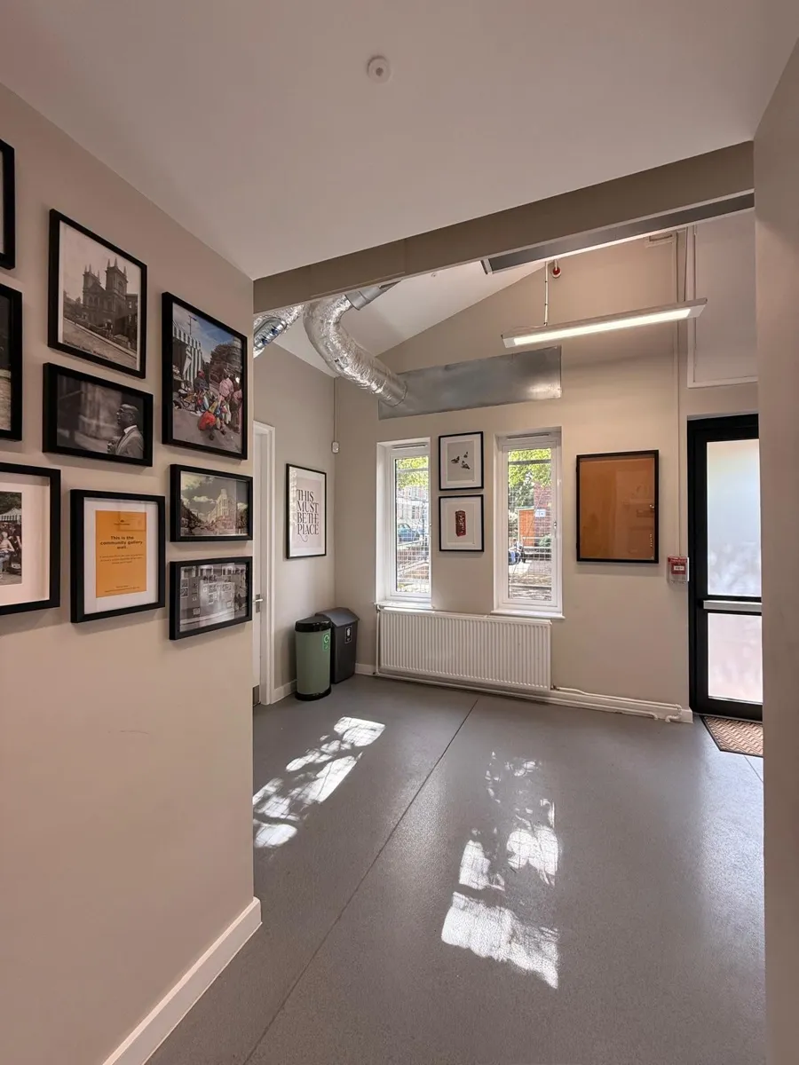 The refurbished lobby at Lydford Community Hall, with a community photo gallery wall on the left, new windows and a radiator