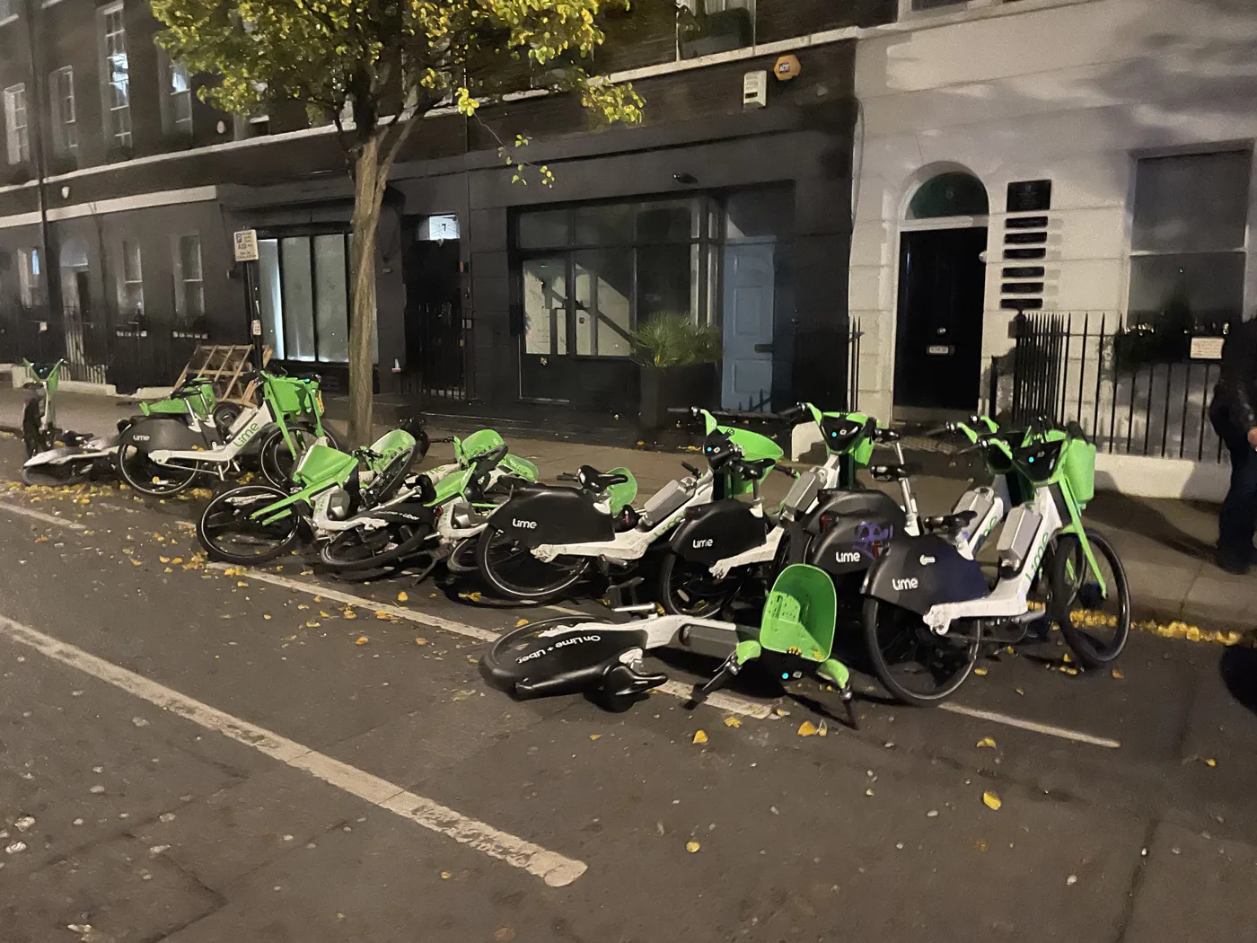Lime hire bikes toppled across a London pavement. Operators have agreed to remove carelessly parked bikes faster.
